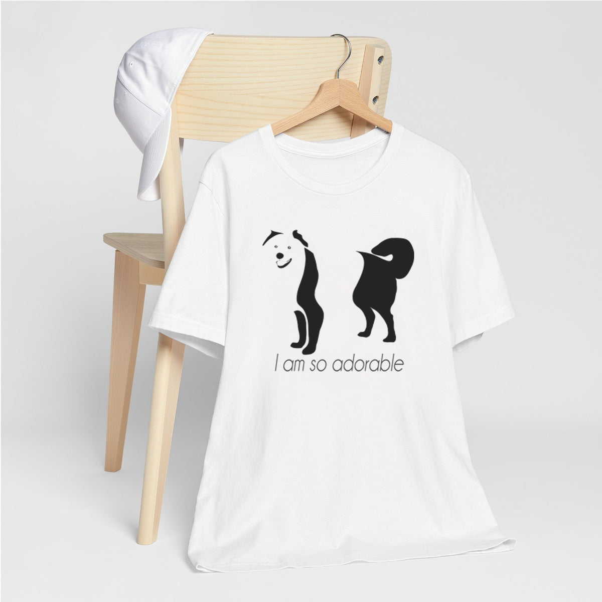 White crew neck short sleeved t-shirt, featuring an adorable Australian Shepherd hand drawn silhouette graphic print with the text "I am so adorable." underneath the dog.Female model shown back side of a white, crew neck short sleeved t-shirt.