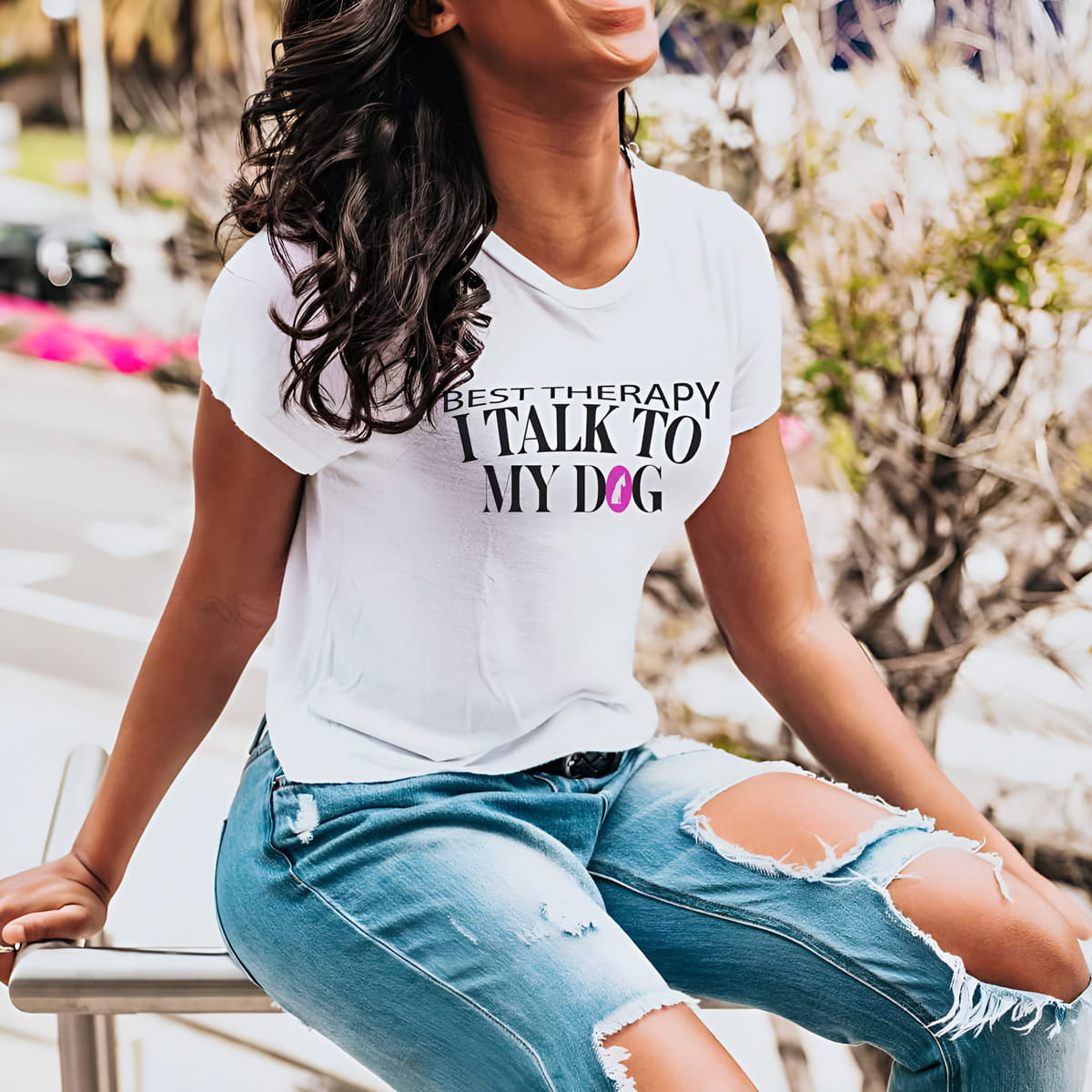 White crew neck short sleeved t-shirt, feature a graphic ”best therapy i talk to my dog” quote a cross chest. woman sitting outdoor