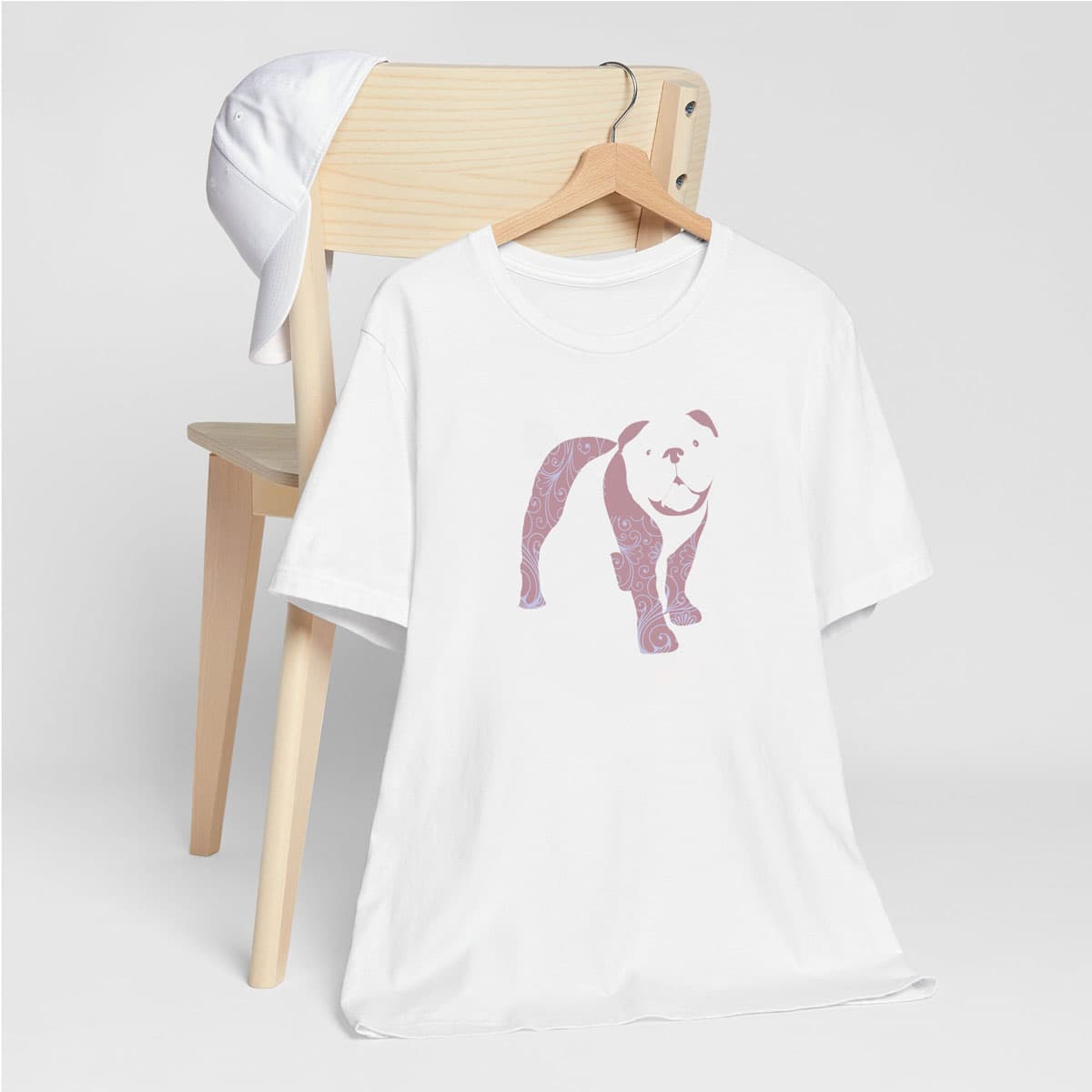 White crew neck short sleeved t-shirt, features a charming bulldog silhouette with floral, and swirl pattern design. Female model shown in close-up to highlight print and fit.