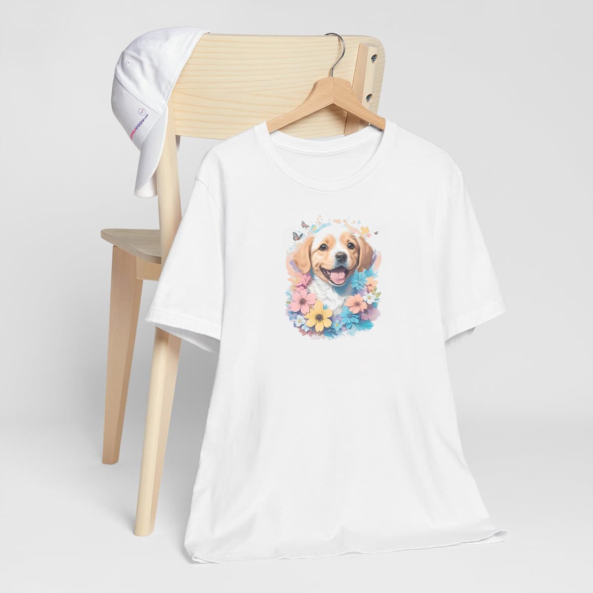White crew neck short sleeved t-shirt, Feature a happy Golden Retriever puppy dog face, with a delight colorful floral wreath wrapping around. T-shirt hanging on chair shown in close-up to highlight print and size