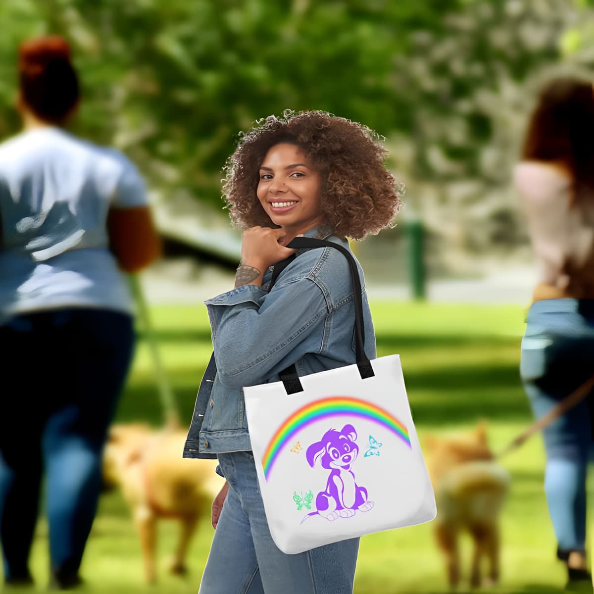Woman standing in a dog park, carry on her shoulder a White spun canvas fabric tote bag, with black handle stripped, on the tote is a cute graphic cartoonist puppy dog sitting with a happy face, surrounded by colorful sizes butterflies, above is a colorful rainbow "