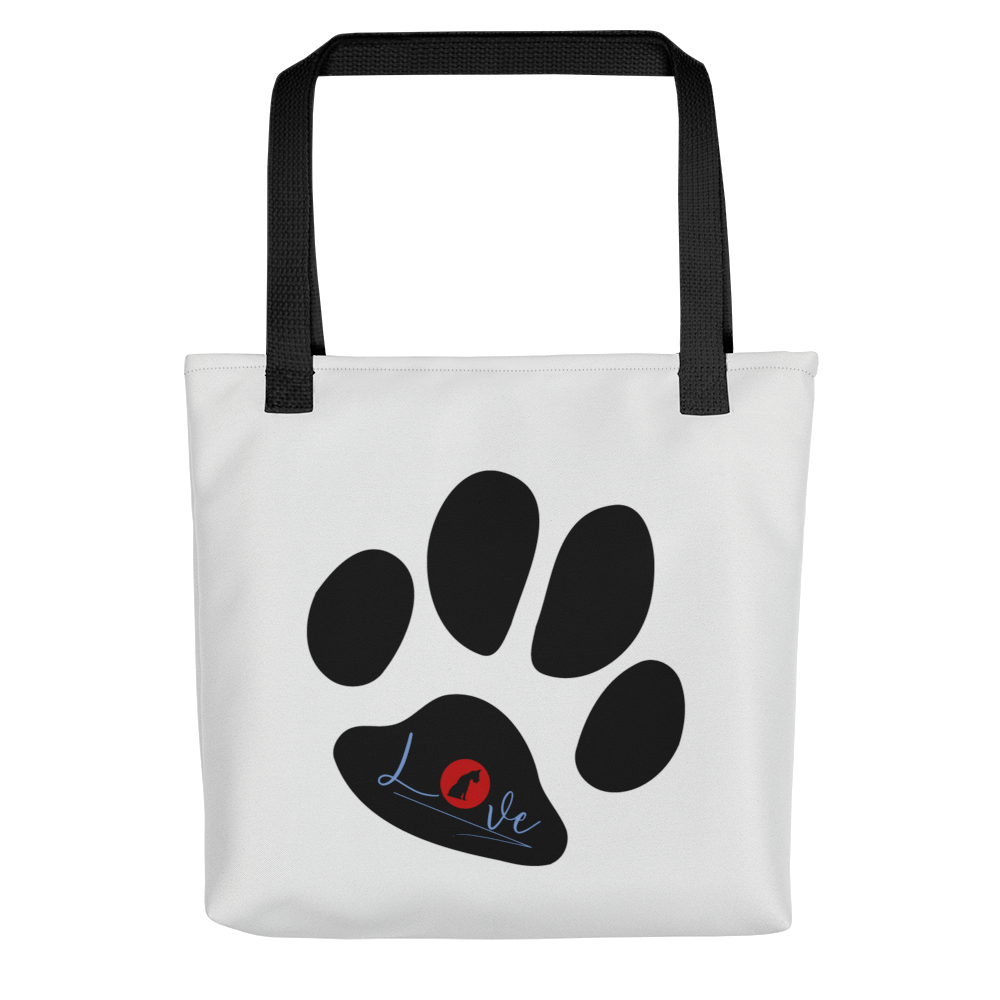 White spun canvas fabric tote bag, with black handle stripped, on the tote is cute graphic large paw, on top of the large paw is the text "love" the letter "o" in "love" is a red logo of a dog sitting