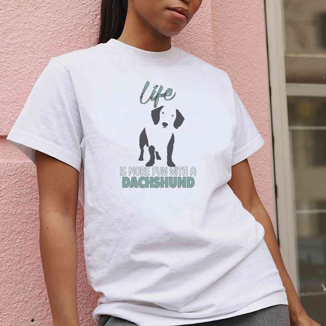 Women standing outside, wearing a White crew neck short sleeved t-shirt, feature a standing cute Dachshund in black/white silhouette with a "life" quote "life is more fun with a Dachshund.