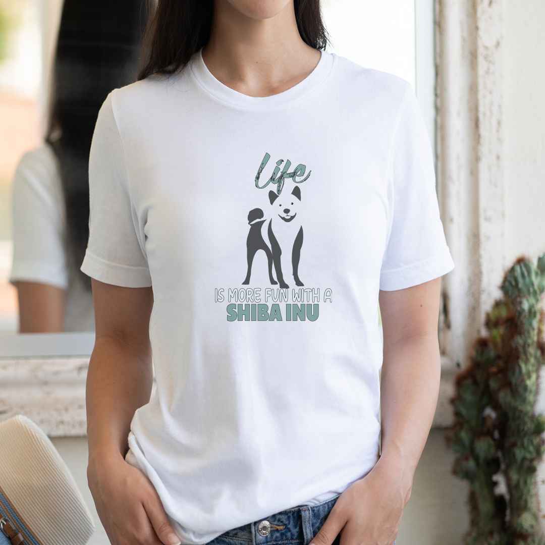 women standing wearing a white short sleeve crew neck t-shirt, featuring a black one-line graphic silhouette of a cute Shiba-Inu standing, with the message"life is more fun with a Shiba Inu.