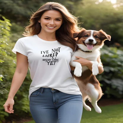Women holding a dog, standing in a garden. She is wearing a white crew neck short sleeved t-shirt, feature a funny message " I´ve not licked anyone today yet" in bold black graphic style.