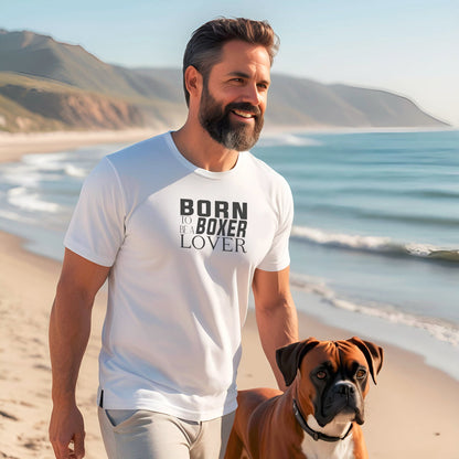 man walking on the beach wearing a white crew neck short sleeved t-shirt, feature “BORN TO BE A BOXER LOVER” text across the front. Together with a boxer dog enjoying the outdoor
