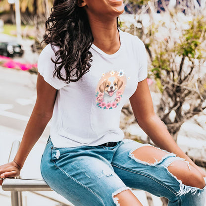 Woman sitting outside wearing  a White crew neck short sleeved t-shirt, feature a graphic vibrant colorful hand-drawn dog face of a  Cavalier King Charles spaniel Puppy sitting in floral wreath.  