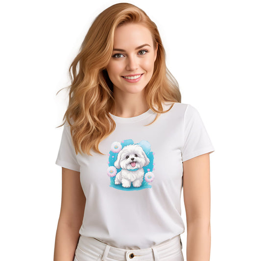 White crew neck short sleeve t-shirt with a colorful hand-drawn Coton de tulear puppy graphic standing in a floral garden. Woman models the shirt, close up showing bold dog art, cute pet-themed fashion