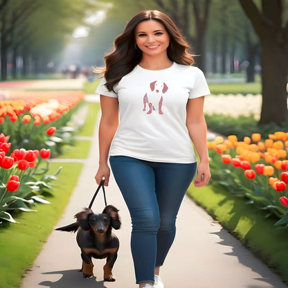 Women walking in a tulip park, with a cute dachshund in leash. She is smiling wearing a white crew neck short sleeved t-shirt, feature a Dachshund silhouette with floral and swirl pattern design in vibrant colors.