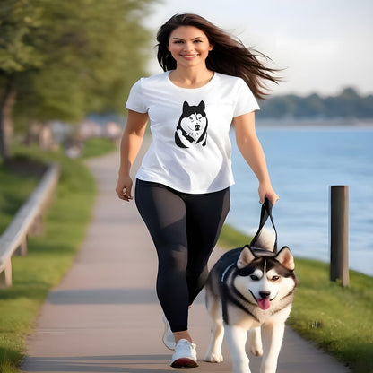 Women running by the lake, with a Husky in leash. she is wearing a white crew neck short sleeved t-shirt, features a one-line graphic silhouette of a cute hand-drawn Husky's face with sparkling blue eyes.