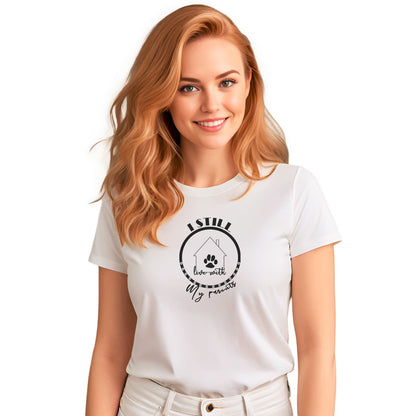 White crew neck short sleeved t-shirt, showcases a cartoon hand-drawn house with a dog paw, circled by the funny quote "I still live with my parents. Female model shown in close-up to highlight print and fit.