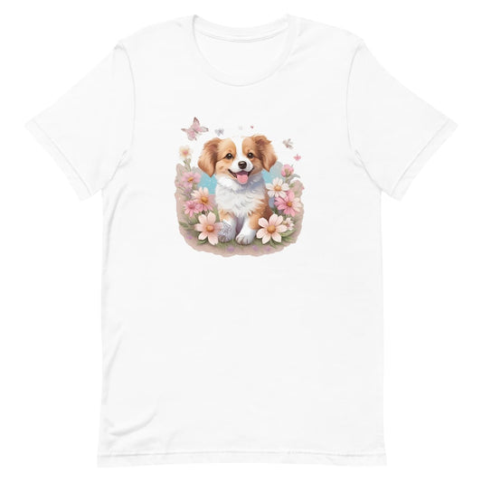 White crew neck short sleeved t-shirt, feature an adorable Spaniel pup frolics amidst a bouquet of blossoms in a charming wicker basket. 