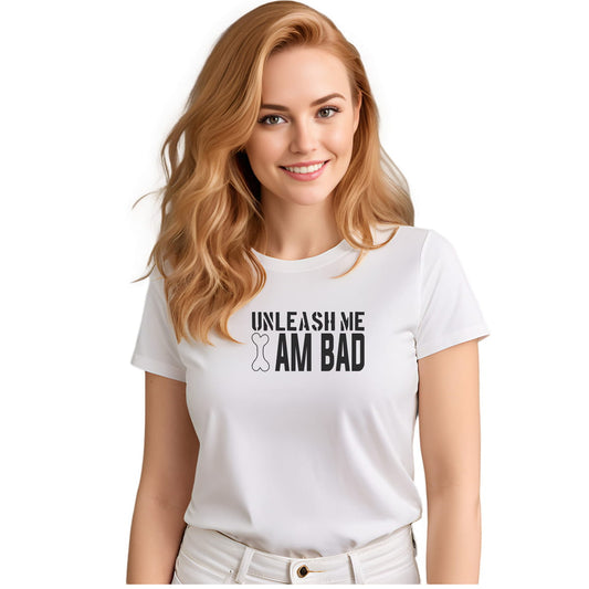 White crew neck short sleeved t-shirt, features a playful humor with a twist, reading the bold black graphic text ”unleash me i am bad” wording I, illustrate a dog bone on its point. Female model shown in close-up to highlight print and fit.