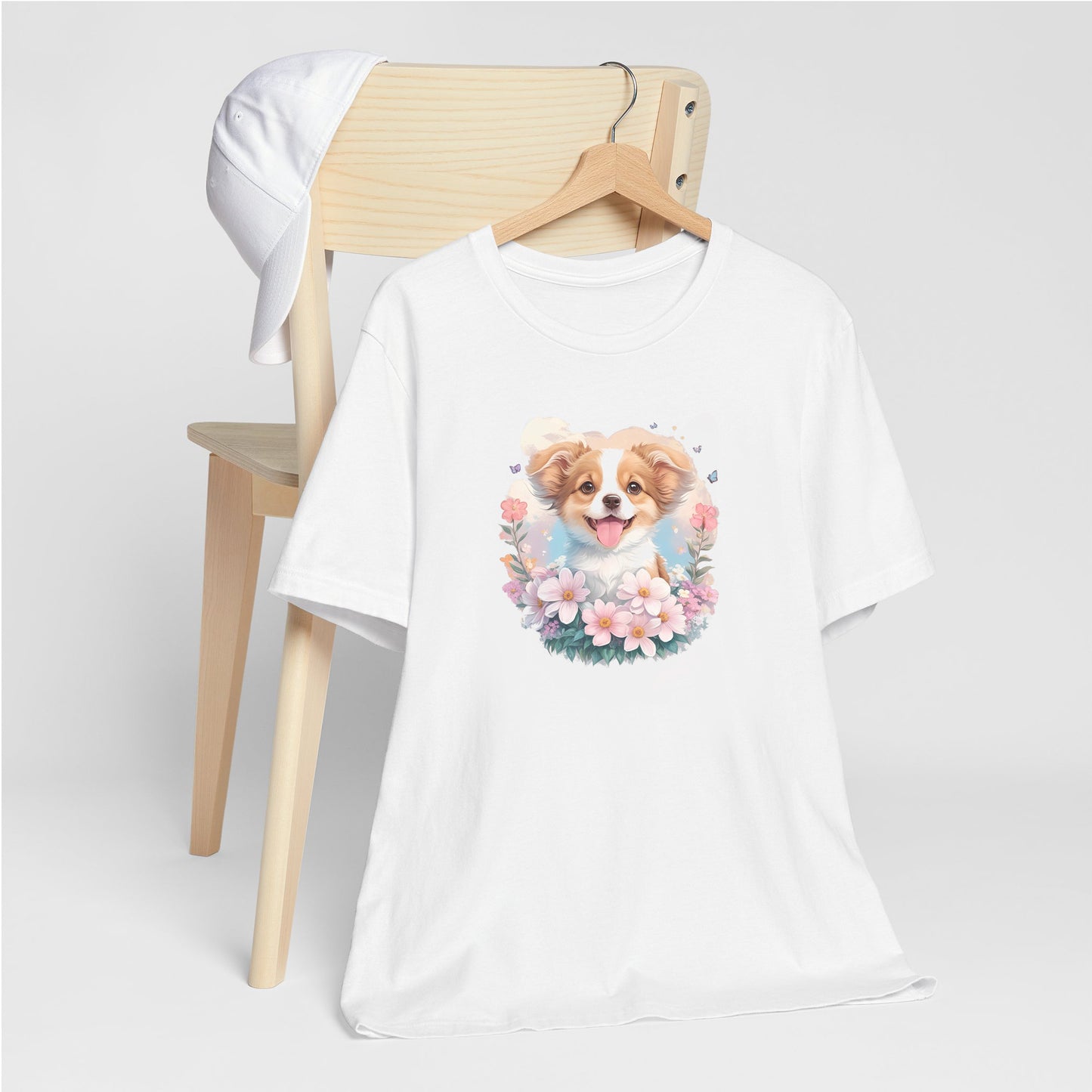 White crew neck short sleeved t-shirt, feature a graphic vibrant colorful hand-drawn dog face of a  Shepherd Puppy sitting in floral wreath. hanger on chair
