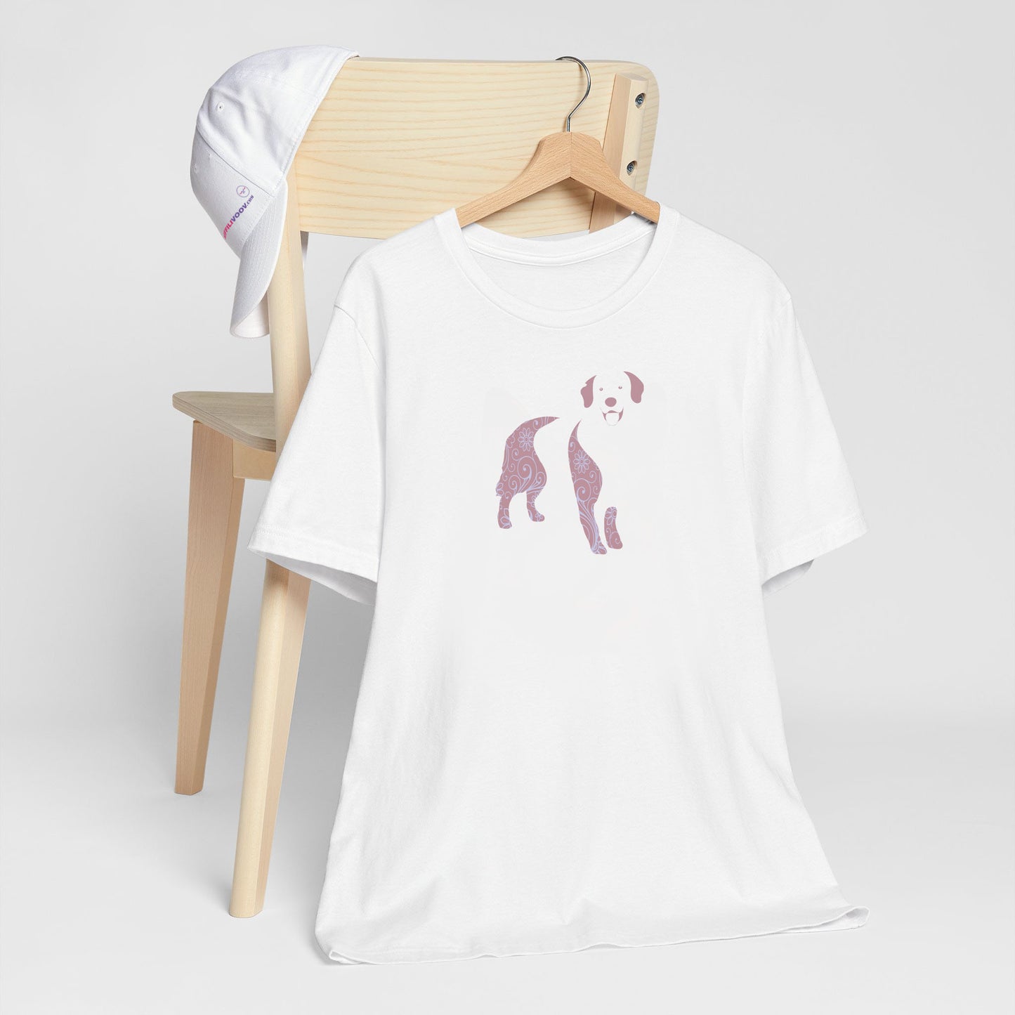 White crew neck short sleeved t-shirt, feature a Golden Retriever silhouette with floral and swirl pattern design in vibrant colors.T-shirt hanging on chair shown in close-up to highlight print and size.