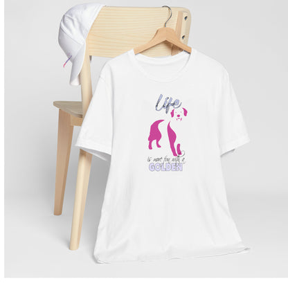 White crew neck short sleeved t-shirt. Featuring an adorable Golden Retriever silhouette in cute pink, the tee also boasts a bold "Life" message and empowering "is more fun with a Golden" phrase. T-shirt hanging on chair shown in close-up to highlight print and size.
