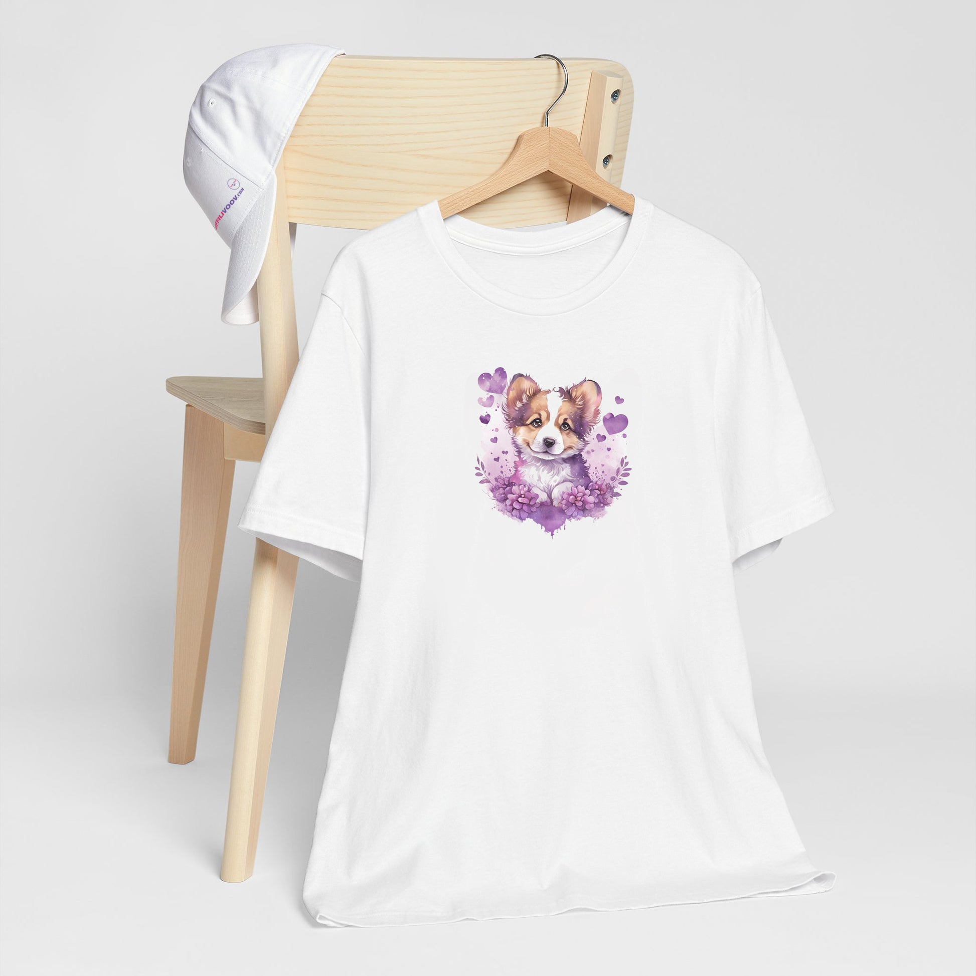 White crew neck short sleeved t-shirt, Features a cute puppy shepherd nestle in hearts and blooming garden.  T-shirt hanging on chair shown in close-up to highlight print and size