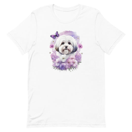 White cotton crew neck unisex short sleeve tshirt, on the apparel is a detailed kawaii illustration print of a lively cute adorable coton de tulear surrounded by floral arrangement in a wicker basket. The design brings a touch of color, warmth, and charm in pastel color palette to the shirt print.