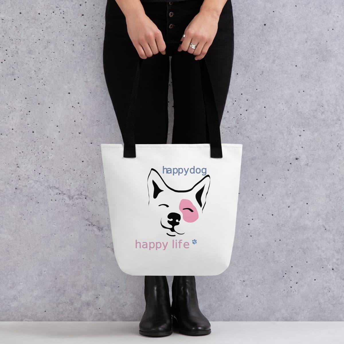 Uni-size 15"x15" white tote polyester canvas bag, with black stripped handle, features a cute Corgi face graphic print, complete with squinty eyes and a happy grin, with a uplifting message "happy dog, happy life" printed on the front. Model shown fit and layout.