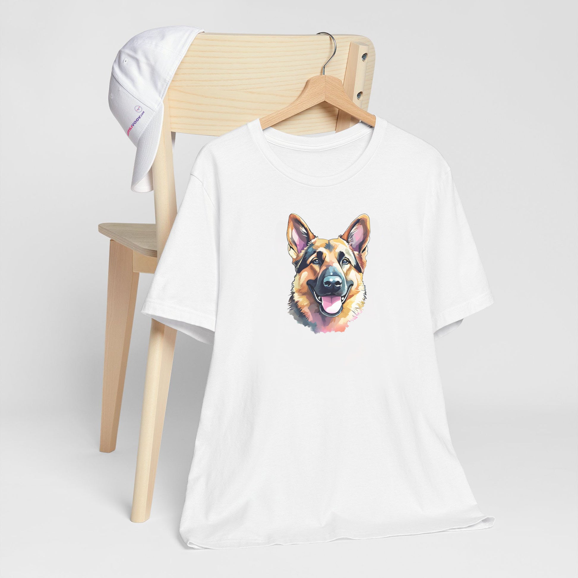 Graphic crisp white short sleeved t-shirt with German Shepherd puppy hand drawn illustration in black, grey, light yellow, and white; hand-drawn face with tongue out. Shirt hanging on a chair in close-up highlighting print 