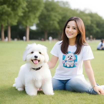 9 White cotton crew neck unisex short sleeve tshirt, on the apparel is a detailed kawaii illustration print of a lively cute adorable coton de tulear surrounded by floral arrangement in a wicker basket. The design brings a touch of color, warmth, and charm in pastel color palette to the shirt print.