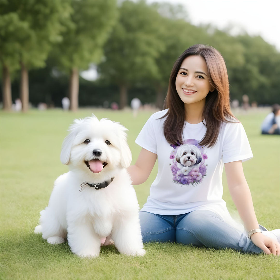 2 White cotton crew neck unisex short sleeve tshirt, on the apparel is a detailed kawaii illustration print of a lively cute adorable coton de tulear surrounded by floral arrangement in a wicker basket. The design brings a touch of color, warmth, and charm in pastel color palette to the shirt print.