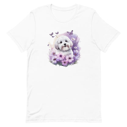 White cotton crew neck unisex short sleeve tshirt, on the apparel is a detailed kawaii illustration print of a lively cute adorable coton de tulear surrounded by floral arrangement in a wicker basket. The design brings a touch of color, warmth, and charm in pastel color palette to the shirt print.