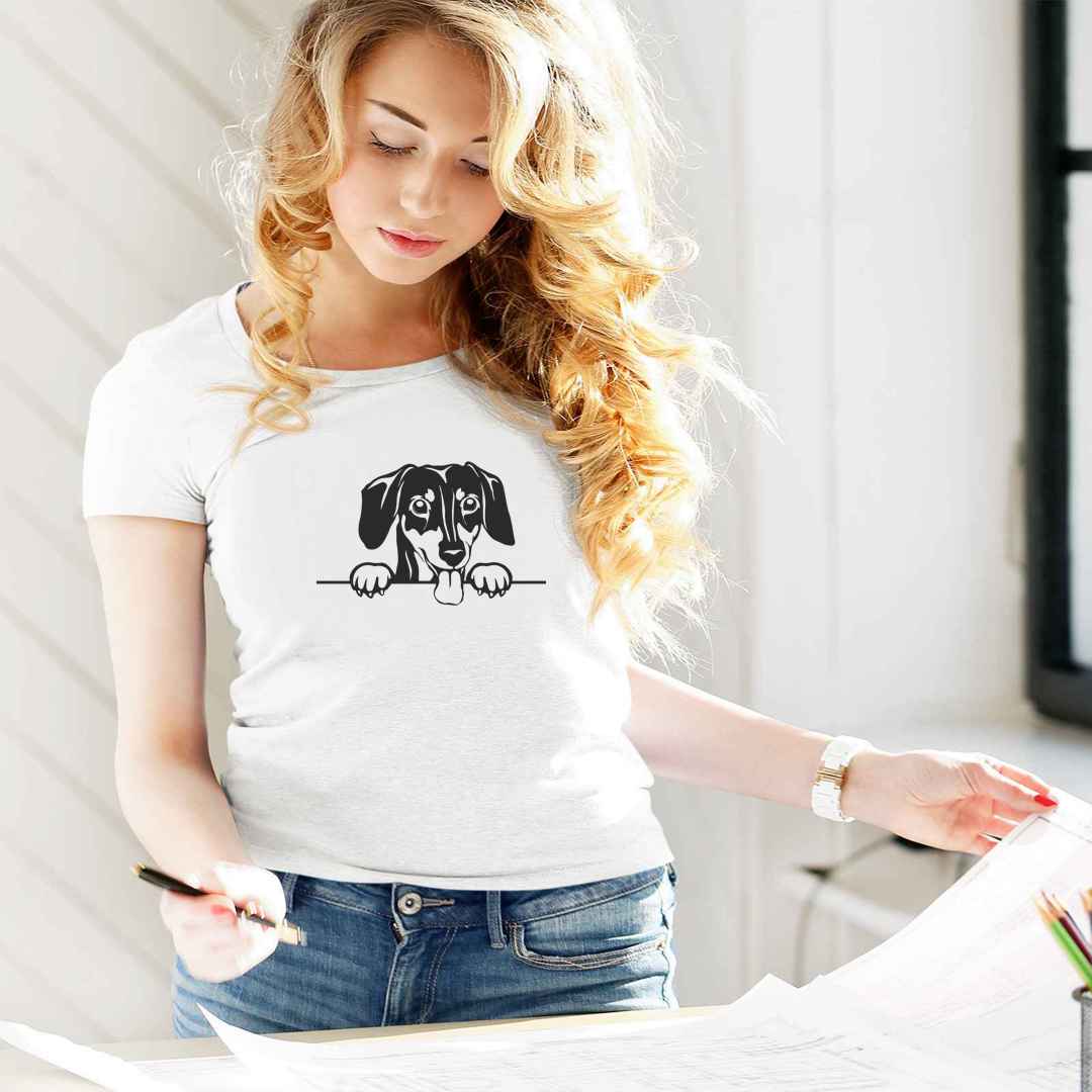 White cotton crew neck unisex  short sleeve tshirt, on the apparel is a black/white graphic one line cute Dachshund dog face,  putting it´s paws on the table