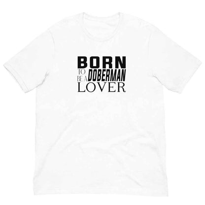 White cotton crew neck unisex shirt, short sleeve, on the apparel is a black and white graphic print with the text BORN TO BE A DOBERMAN LOVER in capital letters in different text styles