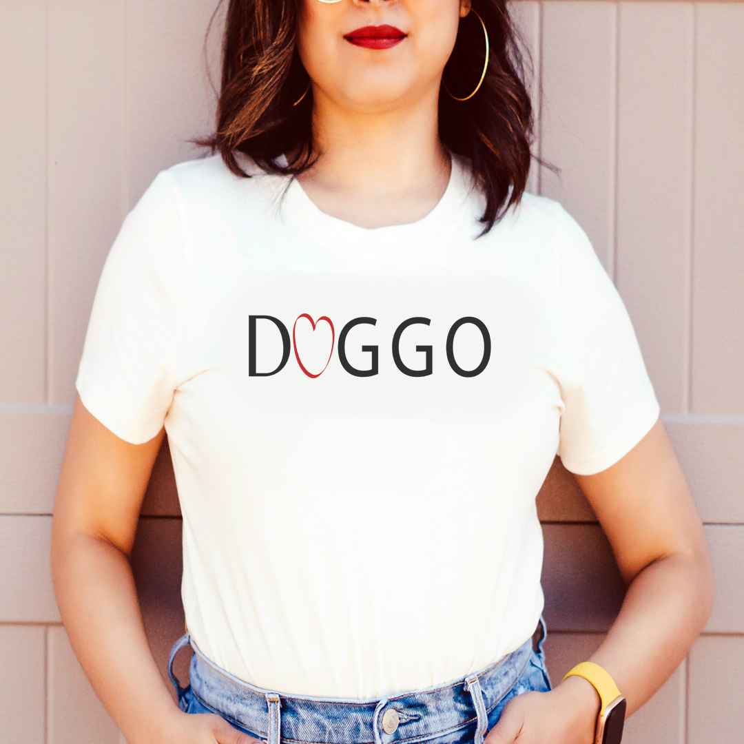 White cotton crew neck unisex  short sleeve tshirt, on the apparel is a graphic black/white text  saying "Doggo"  in cap, the two letter O in "doggo" is a red heart .