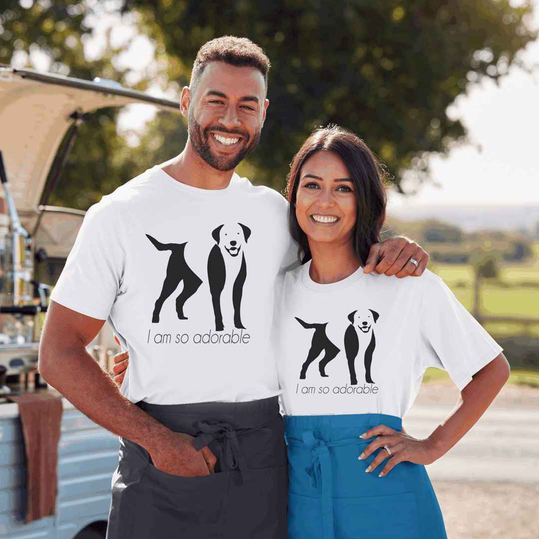 White cotton crew neck unisex  short sleeve tshirt, on the apparel is a black one-line graphic print silhouette of a cute Labrador standing with its tongue out. underneath the dog is the text " i am so adorable" in cap" 