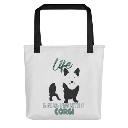 White spun canvas fabric tote bag , on the bag is a black one-line graphic print silhouette of a cute Welsh Corgi dog standing with its tongue out. Above the dog is the text " LIFE" in cap and underneath the dog is the text " is more fun with a Corgi " in cap" 