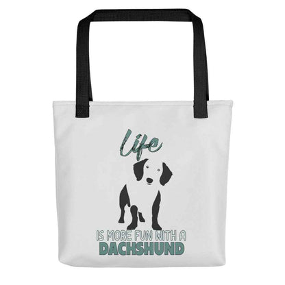 White spun canvas fabric tote bag , on the bag is a black one-line graphic print silhouette of a cute Dachshund dog standing with its tongue out. Above the dog is the text " LIFE" in cap and underneath the dog is the text " is more fun with a Dachshund " in cap"