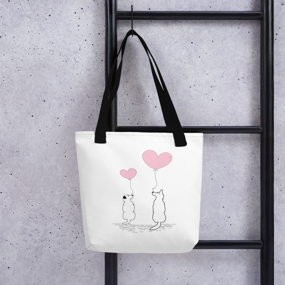 White spun canvas fabric tote bag, with black handle stripped, on the tote is two graphic dogs sitting beside each other. facing each other, with each a pink ballon, holding it string, the theme for this tote is "love is in the air"