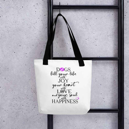 White spun canvas fabric tote bag, with black handle stripped, on the tote is  graphic quote saying" dogs fill your life with joy, your heart with love and your soul with happiness"