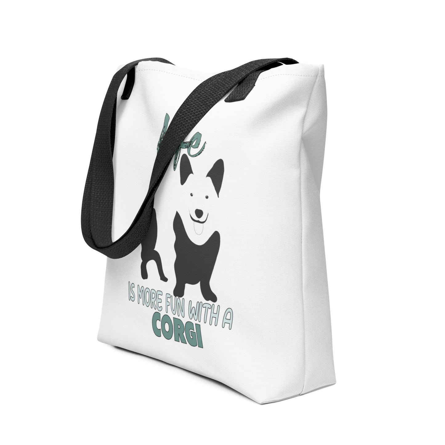 White spun canvas fabric tote bag , on the bag is a black one-line graphic print silhouette of a cute Welsh Corgi dog standing with its tongue out. Above the dog is the text " LIFE" in cap and underneath the dog is the text " is more fun with a Corgi " in cap" 