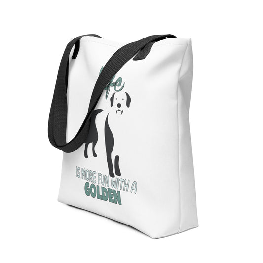 White spun canvas fabric tote bag , on the bag is a black one-line graphic print silhouette of a cute Golden Retriever dog standing with its tongue out. Above the dog is the text " LIFE" in cap and underneath the dog is the text " is more fun with a Golden " in cap"