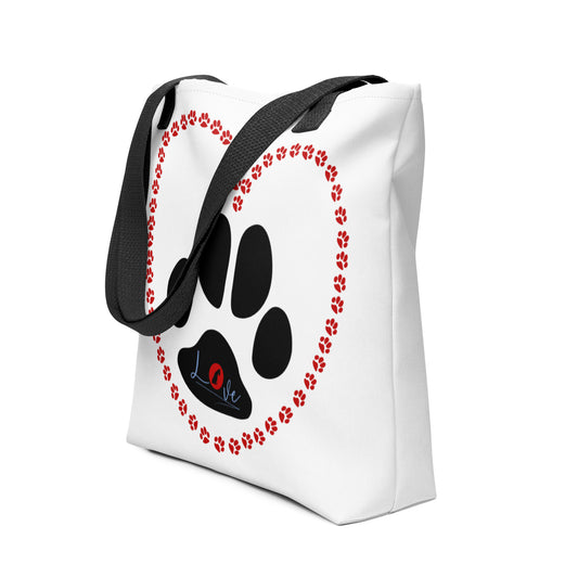 White spun canvas fabric tote bag, with black handle stripped, on the tote is  cute graphic red shaped heart made of paws, inside the heart is a large paw, on top of the large paw is the text "love" the letter "o" in "love" is a red logo of a  dog sitting. 