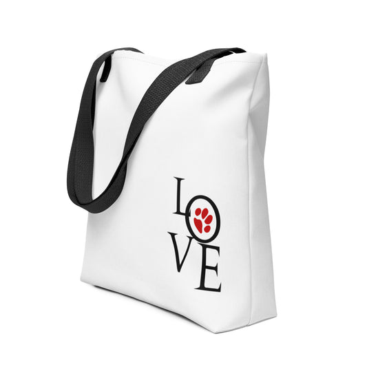 White spun canvas fabric tote bag, with black handle stripped, on the tote is artistic graphic text saying "love" the letter "o" in love is a graphic red dog paw