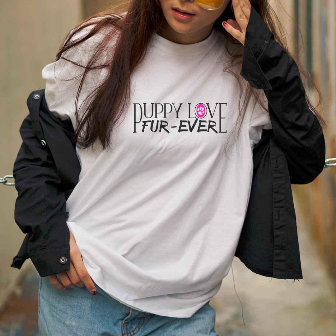 White cotton crew neck unisex  short sleeve tshirt, on the apparel is a graphic black text  saying "puppy love fur-ever"  the letter "o" in love" is a pink graphic shaped paw