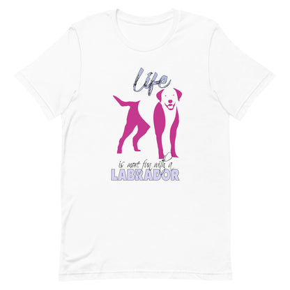 White cotton crew neck unisex  short sleeve tshirt, on the apparel is a graphic print silhouette of a cute adorable Labrador standing , the dog silhouette is in pink color, above the dog is the text " Life" written in tilted purple graphic letter, below is the text " is more fun with a Labrador" in capital letter, the text "Labrador" stands out with its pink color.