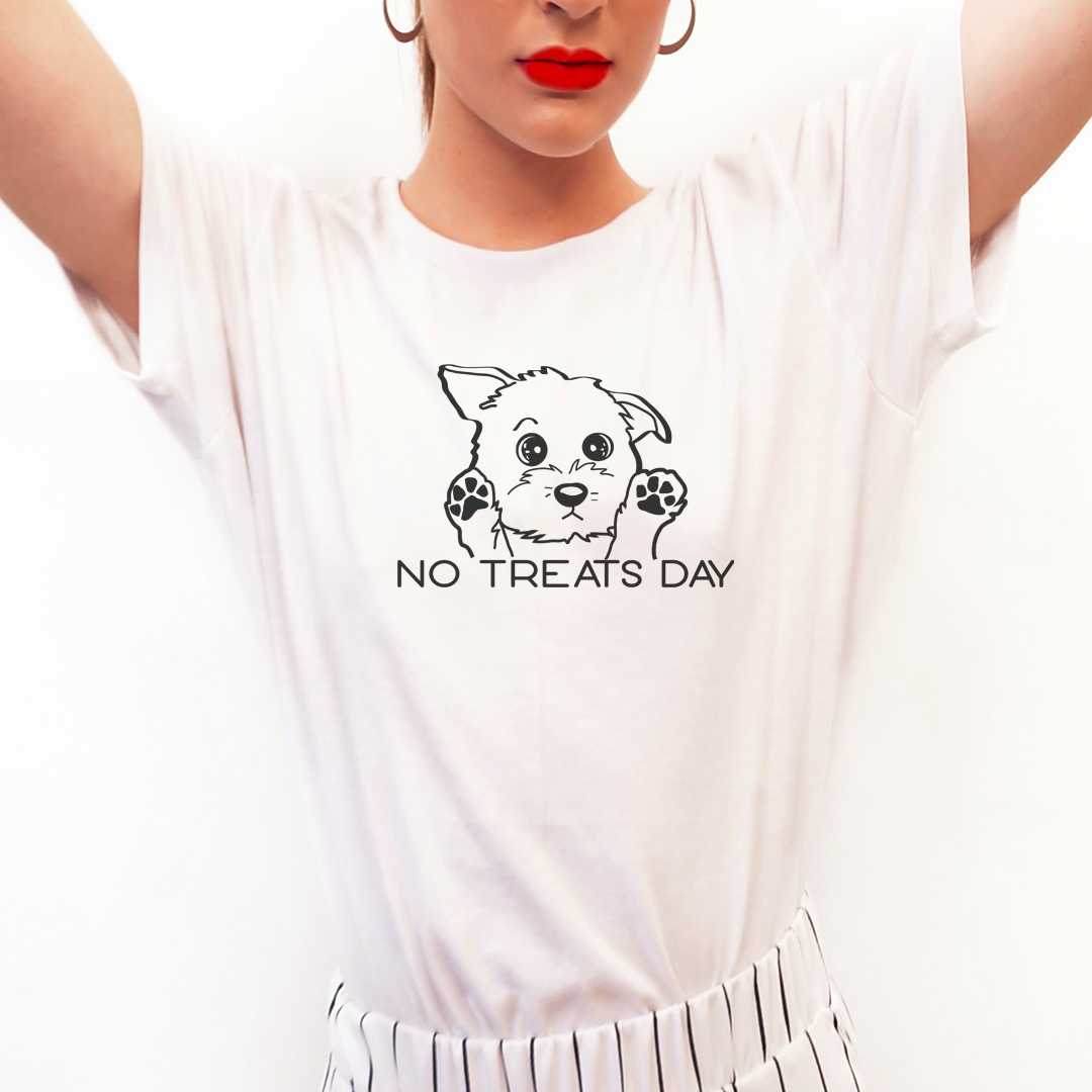 White cotton crew neck unisex  short sleeve tshirt, on the apparel is a one line black graphic of a cute puppy with sparkling eyes and with its paws up in the air, showing its sad mood face, below the dog is the text saying " no treats day" in cap