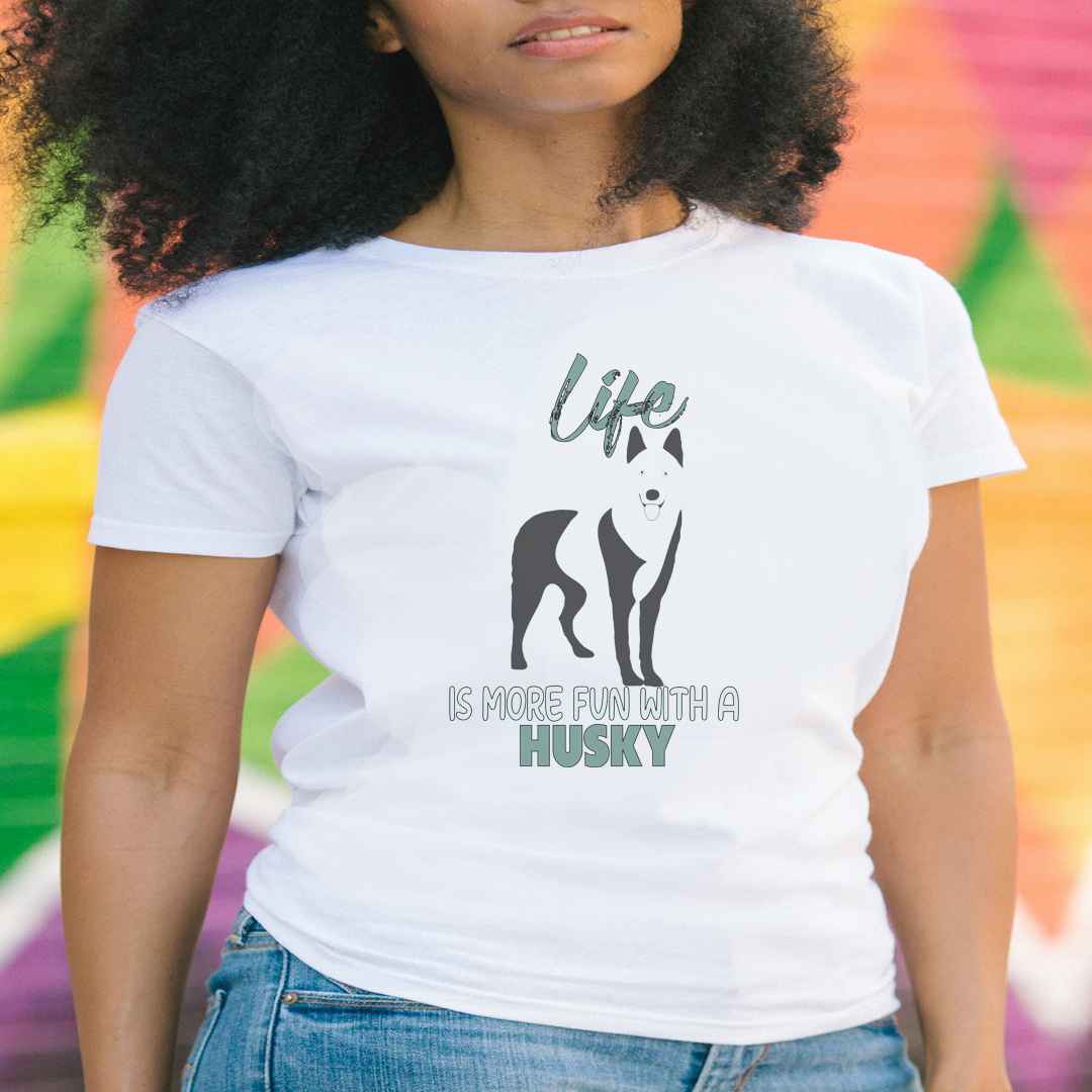 White cotton crew neck unisex  short sleeve tshirt, on the apparel is a black one-line graphic print silhouette of a cute Siberian Husky standing with its tongue out. Above the dog is the text " LIFE" in cap and underneath the dog is the text " is more fun with a Husky" in cap"