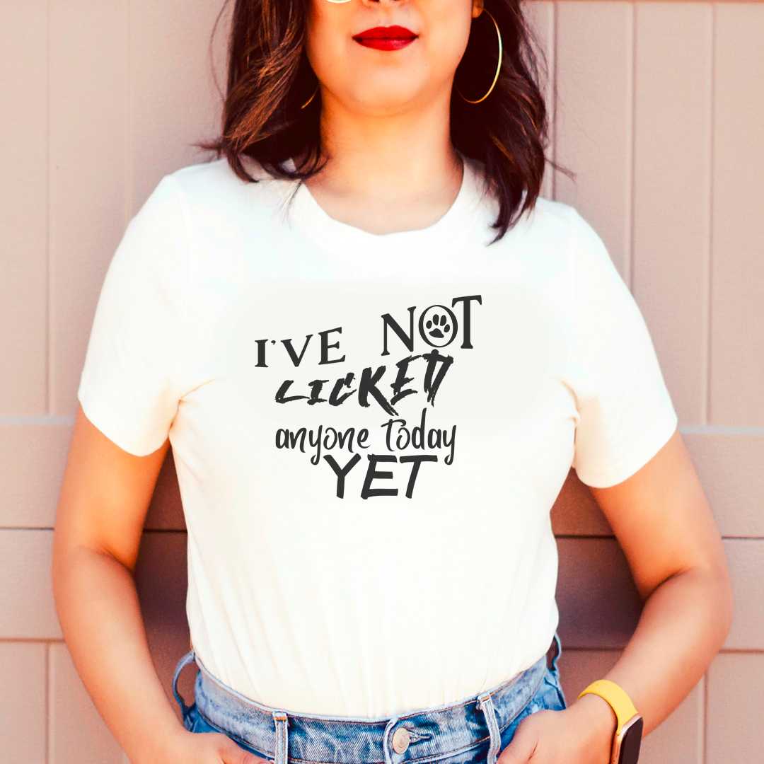 White cotton crew neck unisex  short sleeve tshirt, on the apparel is a graphic black text  saying " I've not licked anyone today yet"  the letter "o" in "not" is a graphic black paw. 