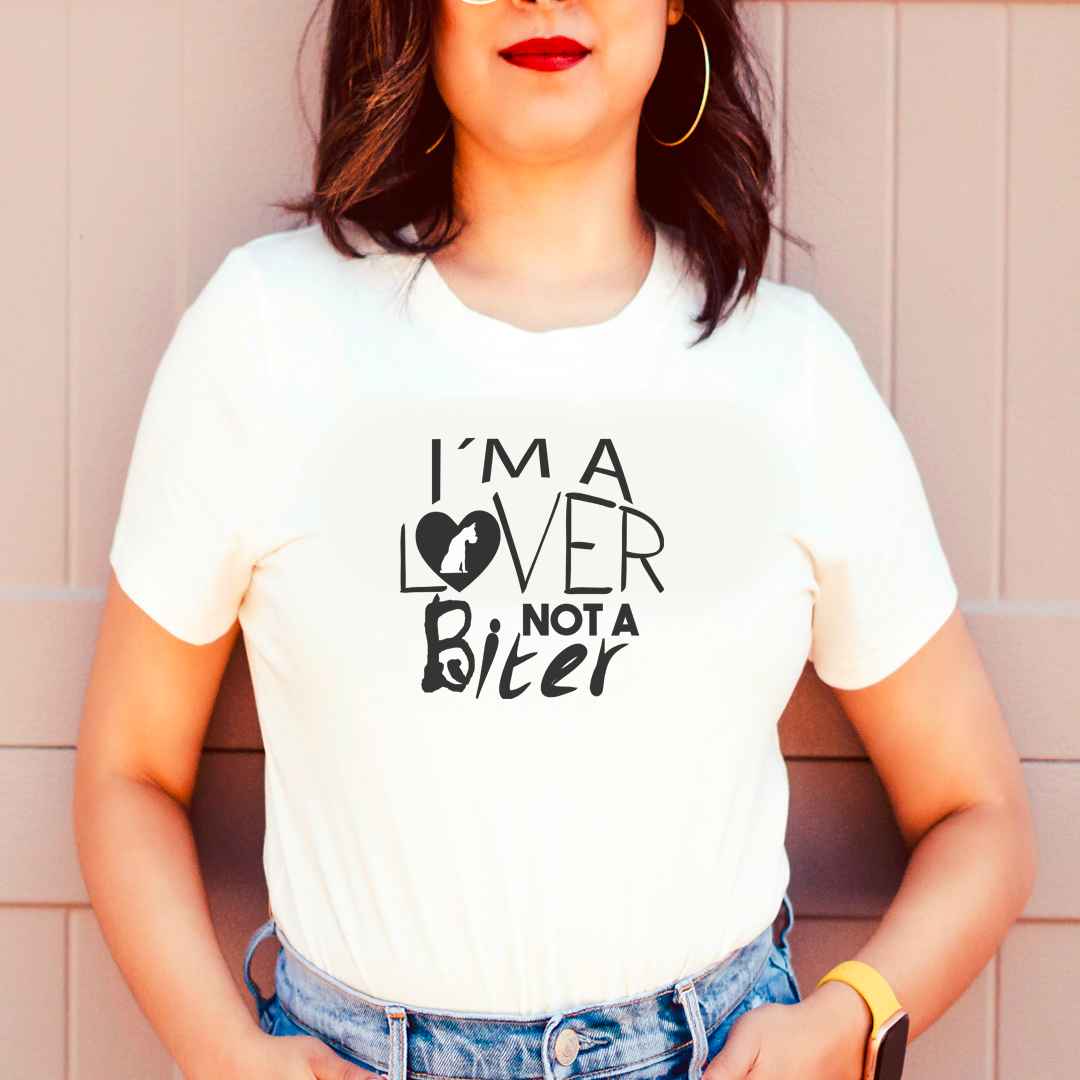 White cotton crew neck unisex  short sleeve tshirt, on the apparel is a graphic black/white text  saying "I am a lover not a biter"  in cap, the  letter O in "lover" is a graphic black heart with a sitting dog