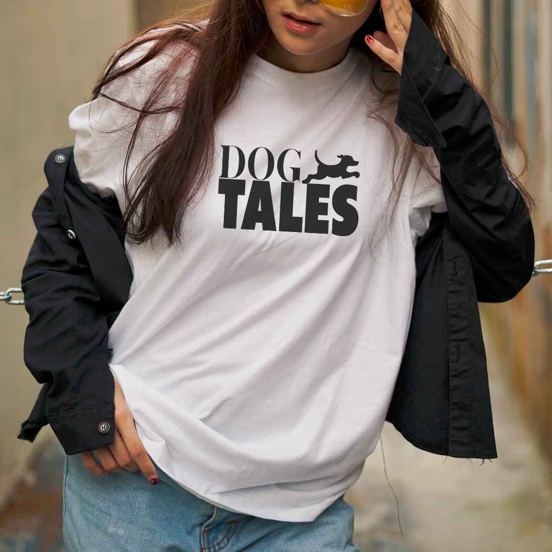 White cotton crew neck unisex short sleeve tshirt, on the apparel is a graphic black text saying "Dog Tales"  in cap, beside the text is a black graphic dog sprinting upward